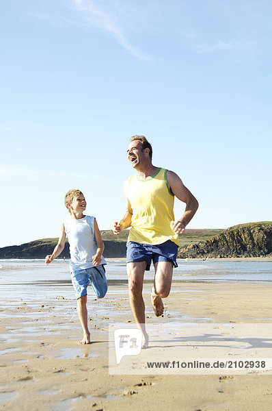 Father and his son running on beach
