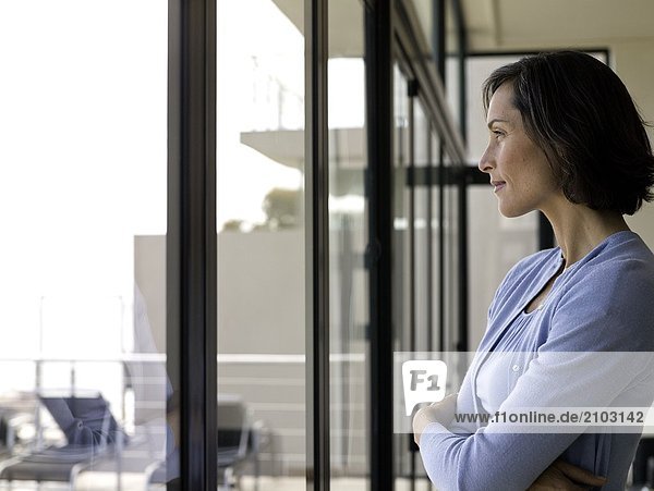 Side profile of woman looking through window