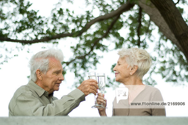 Seniorenpaar beim Trinken mit Champagner im Freien