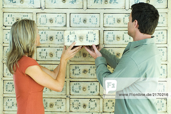 Frau und Mann stellen Schublade in Schrank zusammen