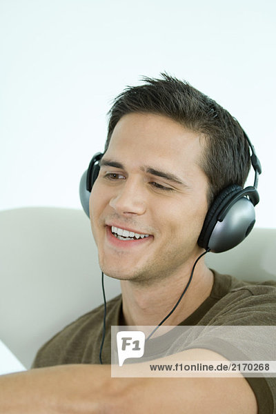 Young man wearing headphones  smiling