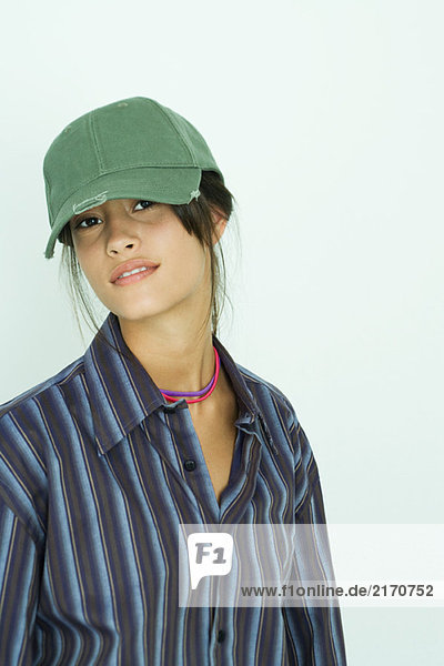 Teenage girl wearing button down shirt and cap  smiling at camera