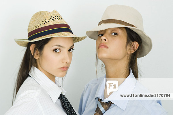Zwei junge Freundinnen mit Hüten und Krawatten  beide mit Blick auf die Kamera