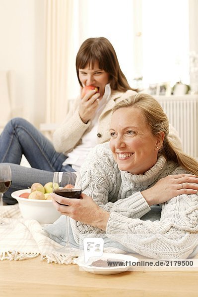 Frau blickt auf ihrer Mutter mit Glas Wein