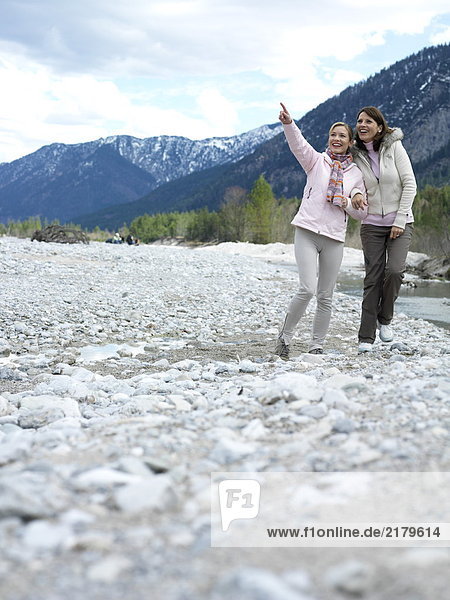 Zwei junge Frauen zu Fuß am Flussufer