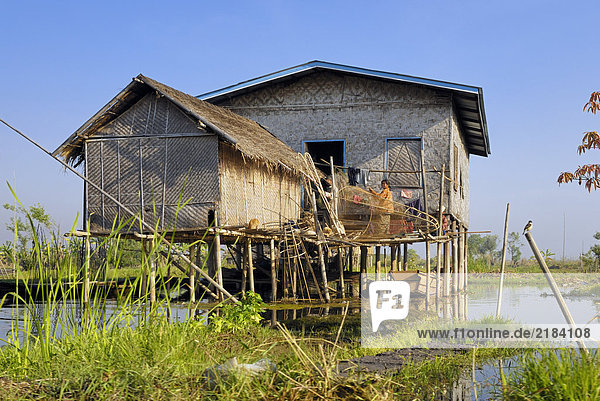 Woman sitting in hut on river  Myanmar