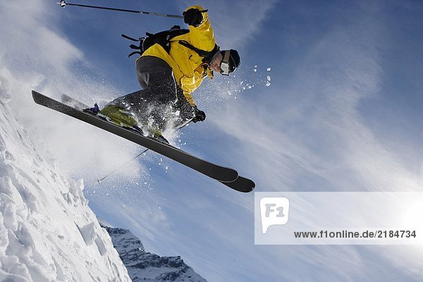 Männliches Skifahren über den Bergrücken