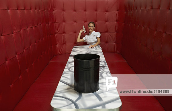 Geschäftsfrau am Tisch mit roter Bestuhlung