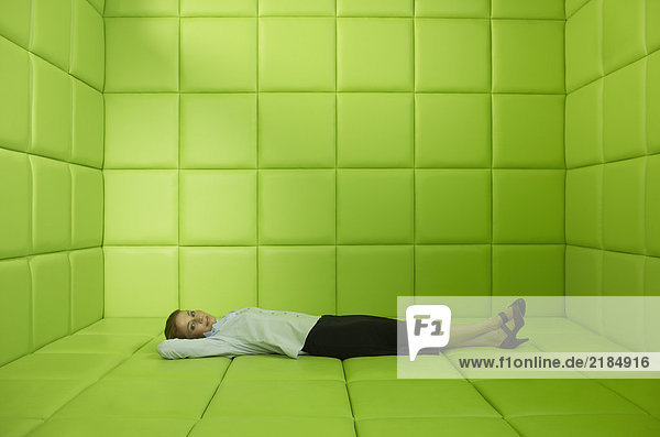 Frau in grüner Gummizelle liegend