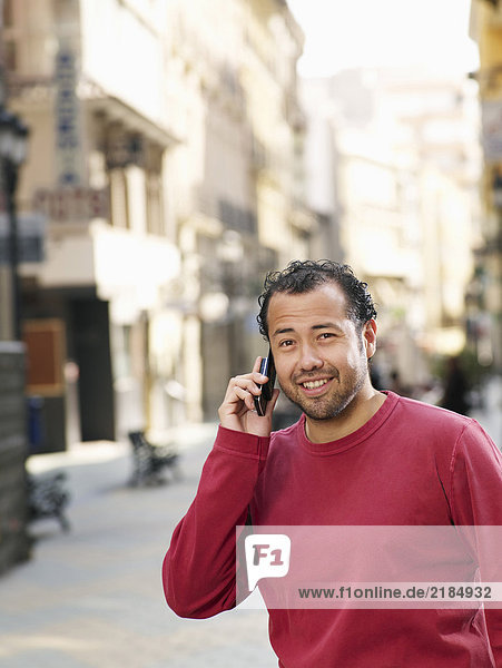 Mann auf der Straße stehend mit dem Handy  lächelnd  Portrait