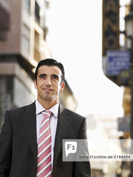 Young businessman standing in street  smiling
