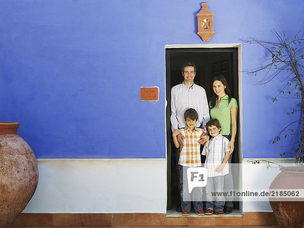 Eltern und zwei Söhne (5-7) im Eingang stehend  Porträt
