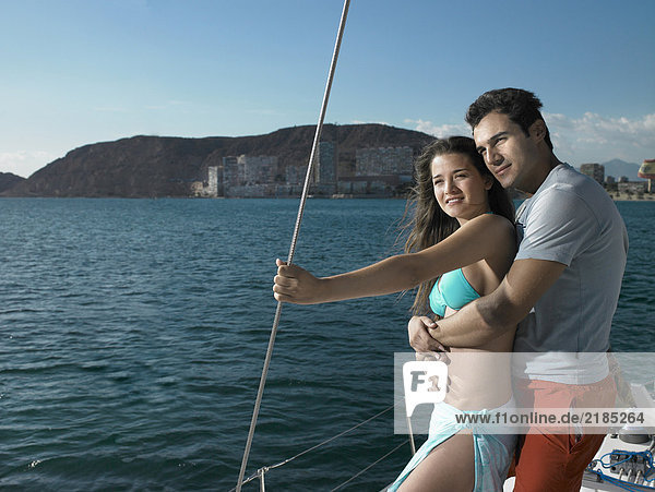 Young couple standing on yacht  smiling
