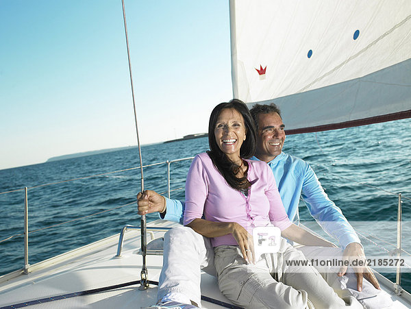 Mature couple sitting on deck of yacht  smiling  portrait