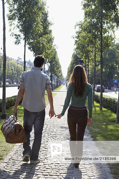Couple walking together with a large bag.