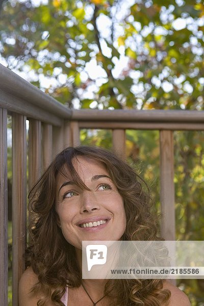 Woman sitting on balcony smiling.