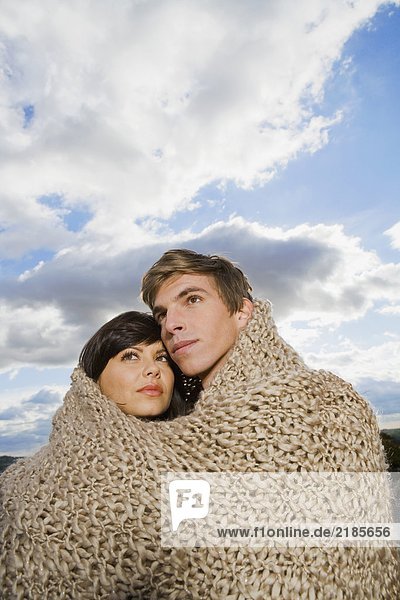 Mann und Frau in Decke gehüllt.