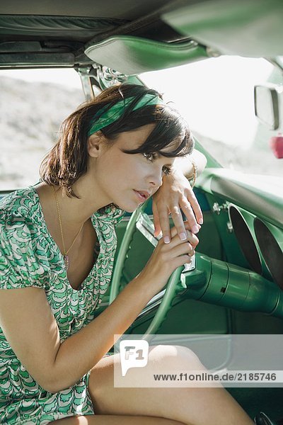 Woman in car looking pensive.