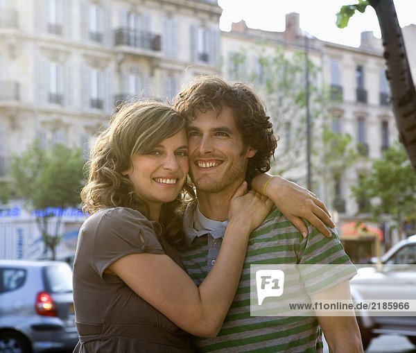 Young couple standing in street  smiling  portrait