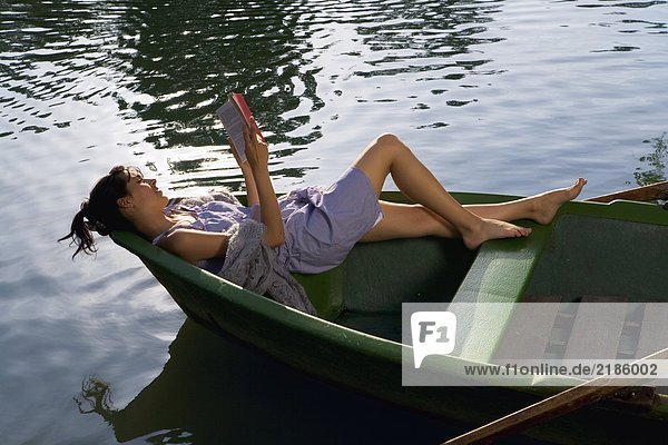 Woman reading a book in boat
