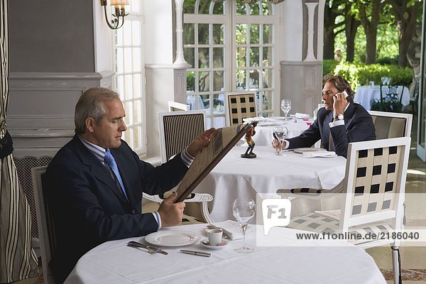 Two businessmen having lunch separately