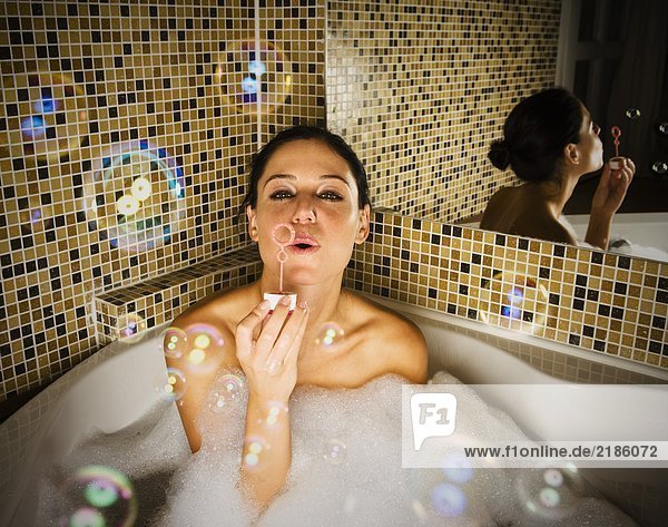 Frau im Bad  die Blasen bläst.