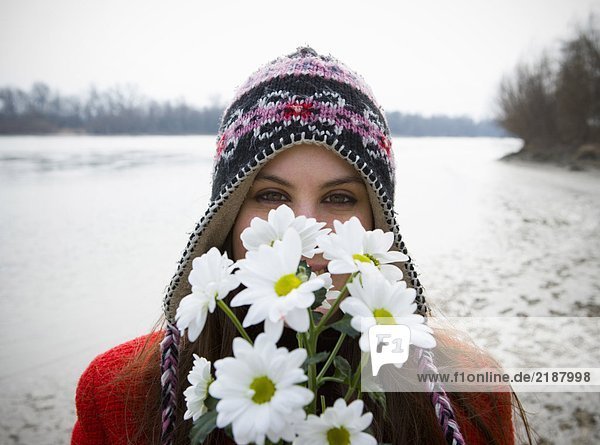 Junge Frau im Freien mit Blumen im Gesicht  Portrait