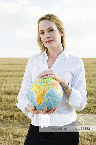 Frau mit Globe im Weizenfeld.
