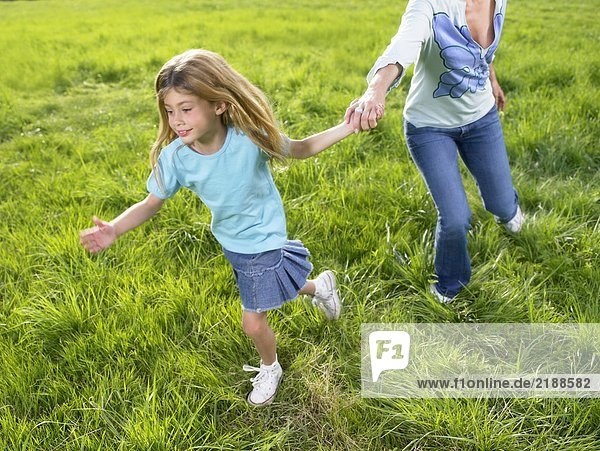Mutter und Tochter spielen auf einem Feld.