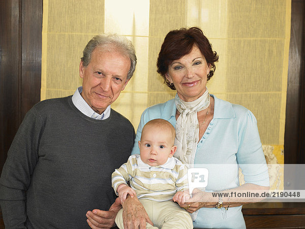 Senior grandparents with baby grandson (1-3 months) smiling  portrait