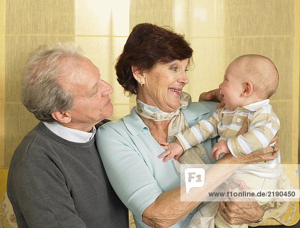 Senior Großeltern mit Enkelkind (1-3 Monate) lächelnd