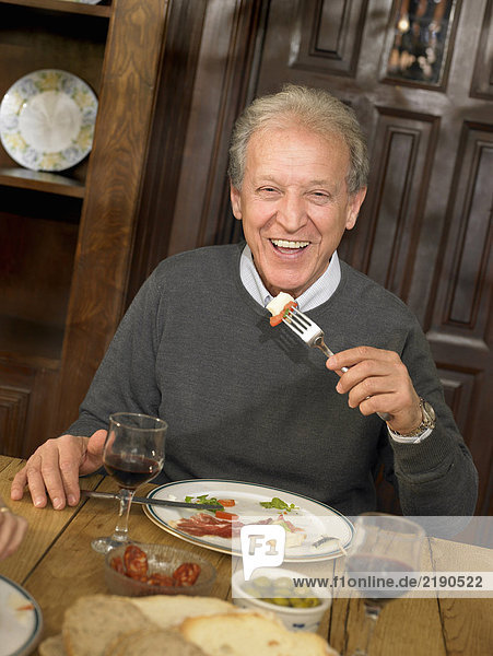 Senior man eating lunch  smiling  portrait