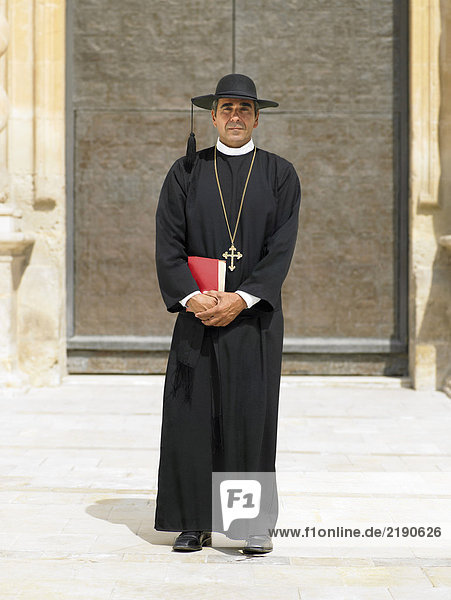 Ganzflächiges Porträt des Priesters durch verzierte Tür  Alicante  Spanien