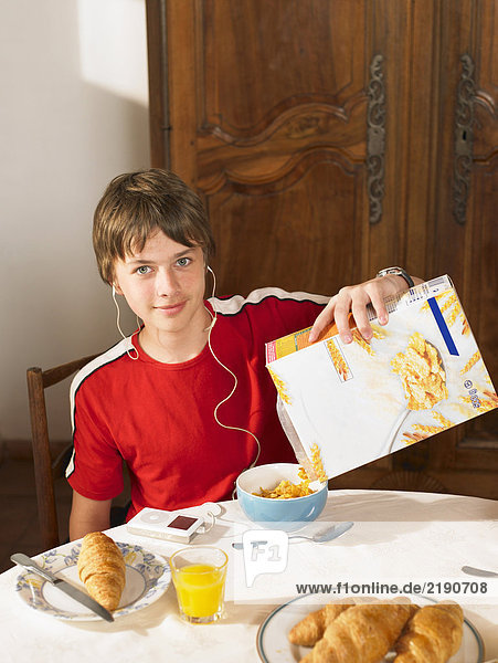 Junge (11-13) mit Kopfhörer beim Frühstück  Portrait