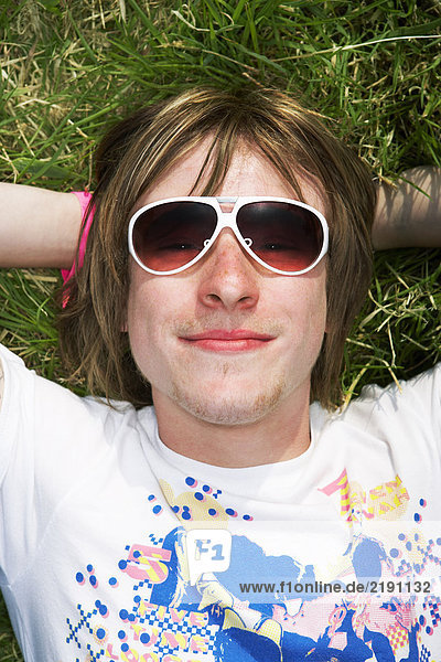 Male lying on grass wearing sunglasses