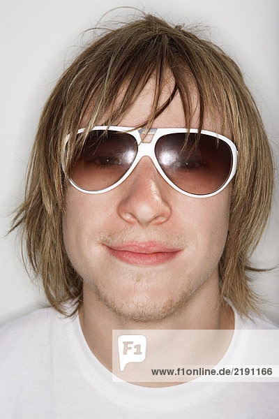 Young male smiling wearing sunglasses