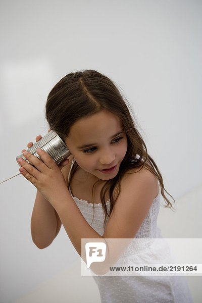 Girl using a tin can as a phone.