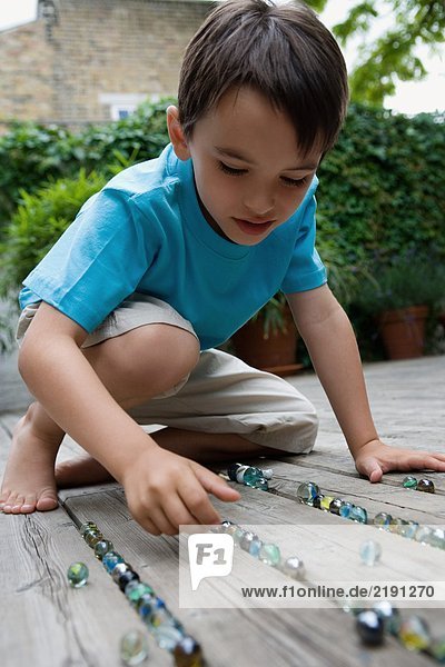 Portrait of a boy playing marbles.