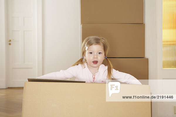 Girl (3-5) carrying large cardboard box  portrait
