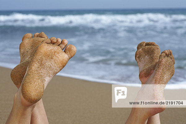 Paar Sandfüße am Strand.