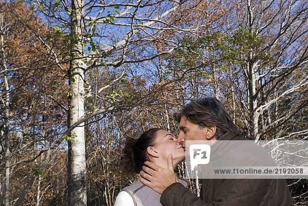 Portrait of a couple surrounded by trees.