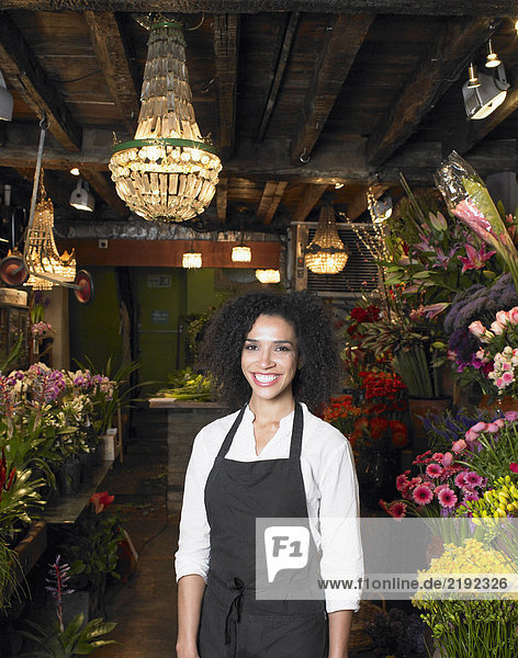 Junge Floristin im Geschäft stehend  lächelnd  Portrait