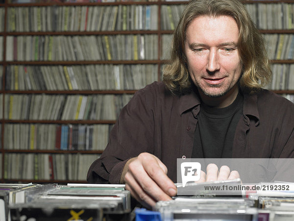 Reifer Mann der sich im Laden CDs ansieht lächelnd