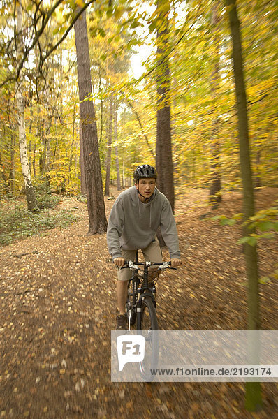Herrenradfahren im Wald mit Helm  Herbst