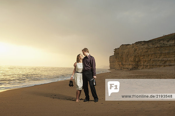 Mann und Frau schlendern am Strand entlang.