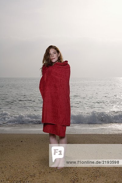 Frau mit einem Handtuch am Strand.