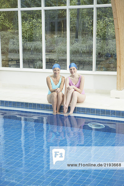 Zwei Frauen am Rande des Swimmingpools.
