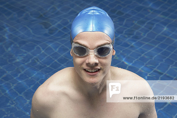 Porträt eines männlichen Schwimmers in einem Pool.