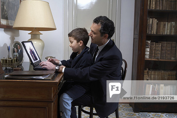 Vater und Sohn (4-6) mit Laptop