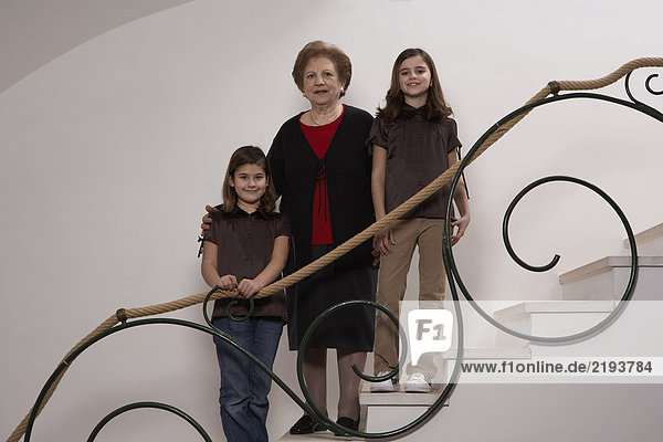 Großmutter mit zwei Enkelinnen (6-11) auf der Treppe  Porträt